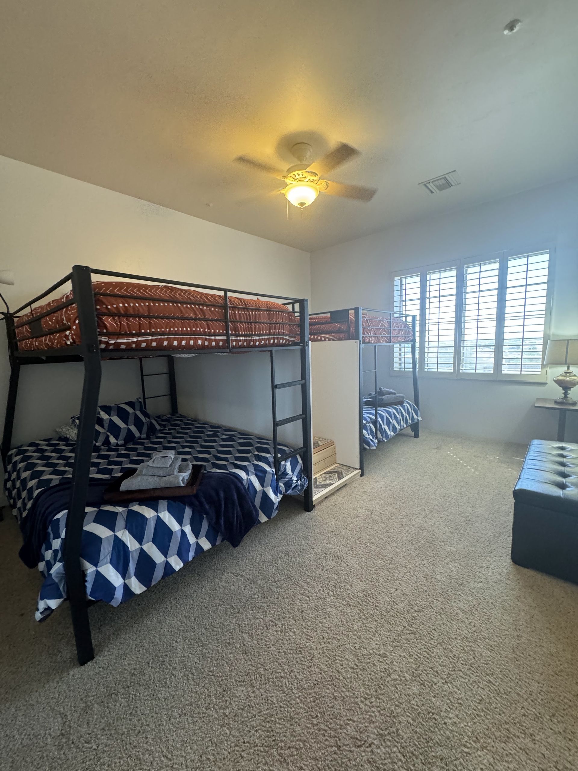 A bedroom with two bunk beds and a ceiling fan.