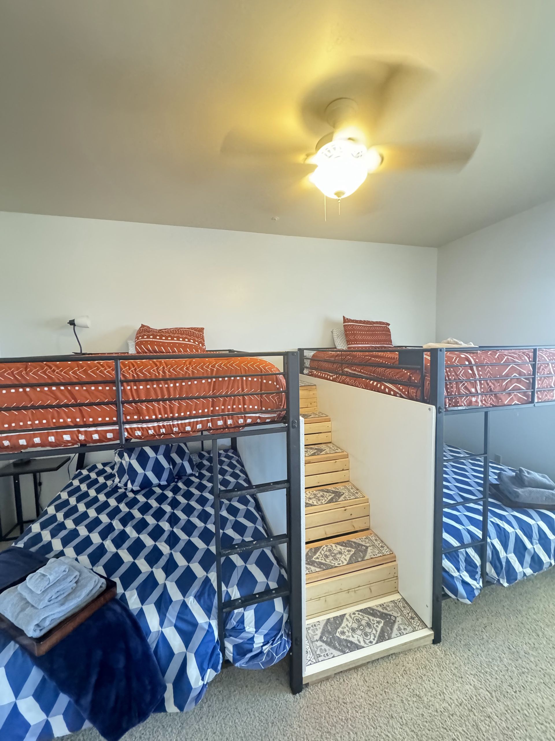 A bedroom with two bunk beds and a ceiling fan.