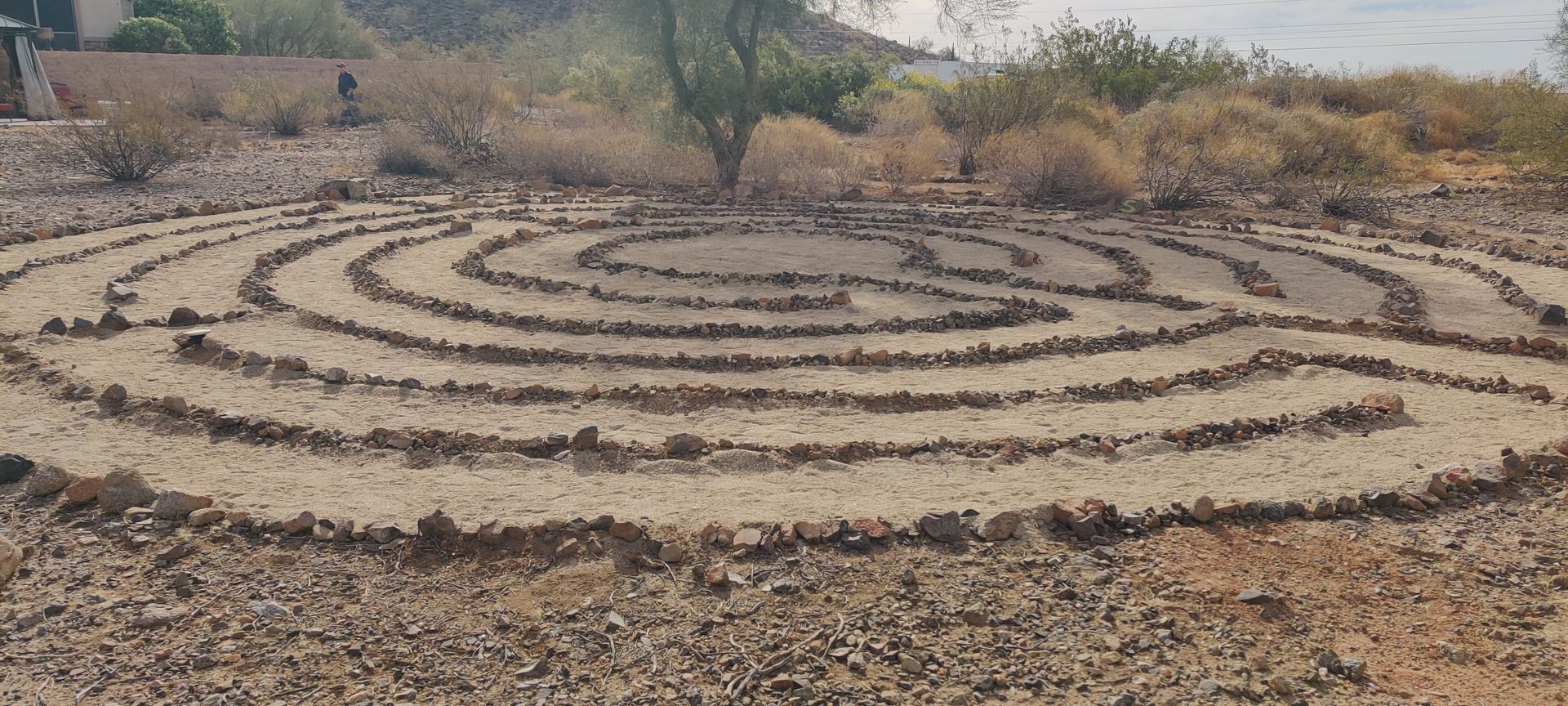 A labyrinth made of rocks in the middle of a field.