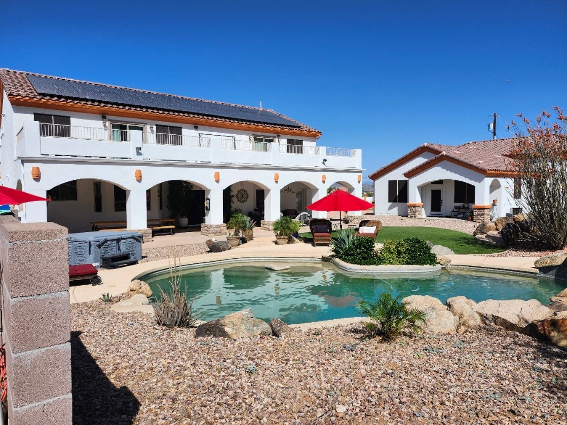 A large house with a large lawn and a pool in the backyard.