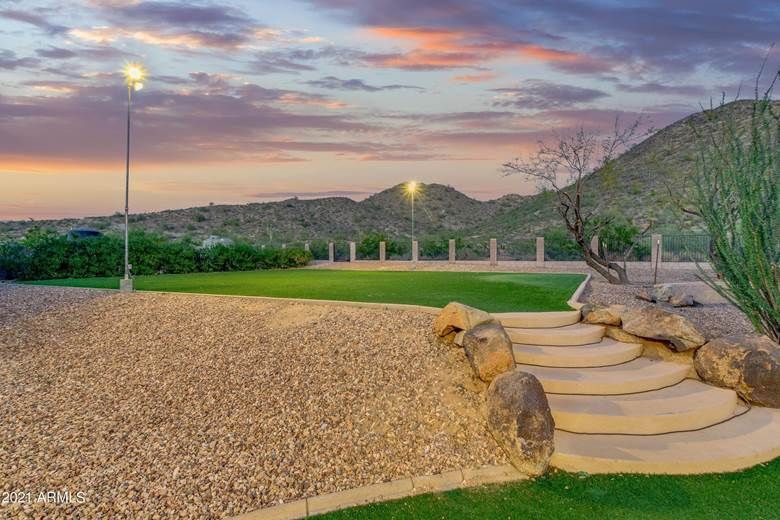 There are stairs leading up to a grassy area with a mountain in the background.