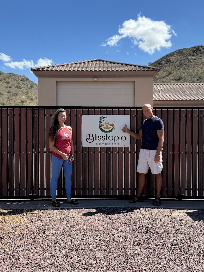 A man and a woman are standing in front of a fence with a sign that says residenc