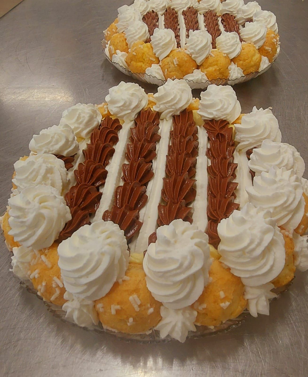 Due torte rotonde decorate con glassa marrone, bianca e gialla.