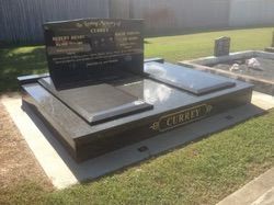Black granite tombstone in a cemetery with the name 