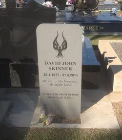 White gravestone with a winged design. Inscription: David John Skinner, dates of birth and death, and a short message — Mackay Monumental Masons In Glenella, QLD