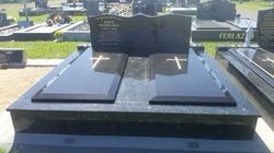Black granite double tombstone with cross carvings and central inscription panel in a cemetery — Mackay Monumental Masons In Glenella, QLD