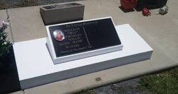 Black gravestone with a photo, on a white rectangular base — Mackay Monumental Masons In Glenella, QLD