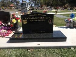 Black Headstone in a Cemetery With Flowers — Mackay Monumental Masons In Glenella, QLD