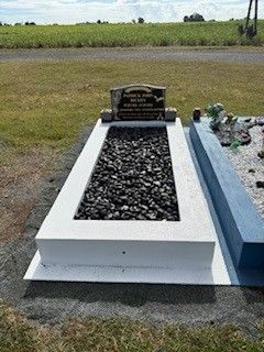 Black granite double headstone in a grassy cemetery.