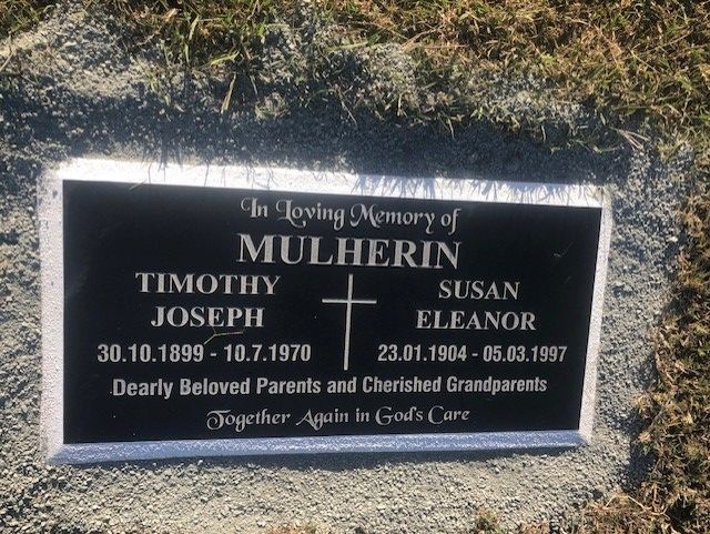 Black memorial plaque with the names Timothy and Susan Mulherin, dates, and a cross.