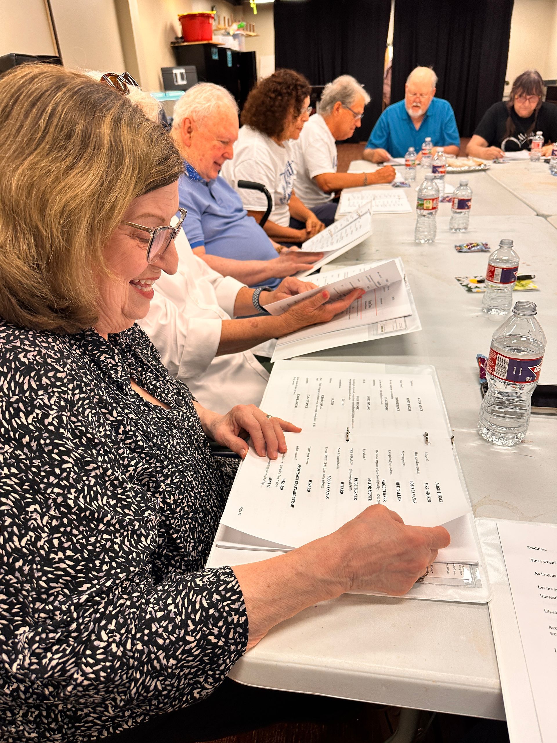 People seated around a conference table, reading printed documents during a meeting