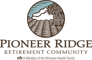 Logo for Pioneer Ridge Retirement Community: circular design with farmland and a sheaf of wheat.