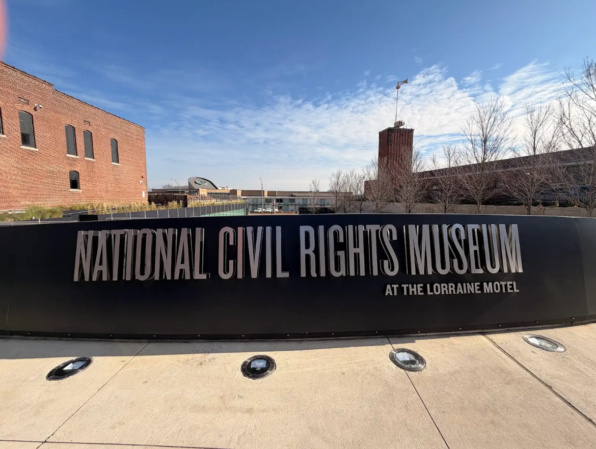 National Civil Rights Museum sign at the Lorraine Motel, Memphis, Tennessee, against a blue sky.