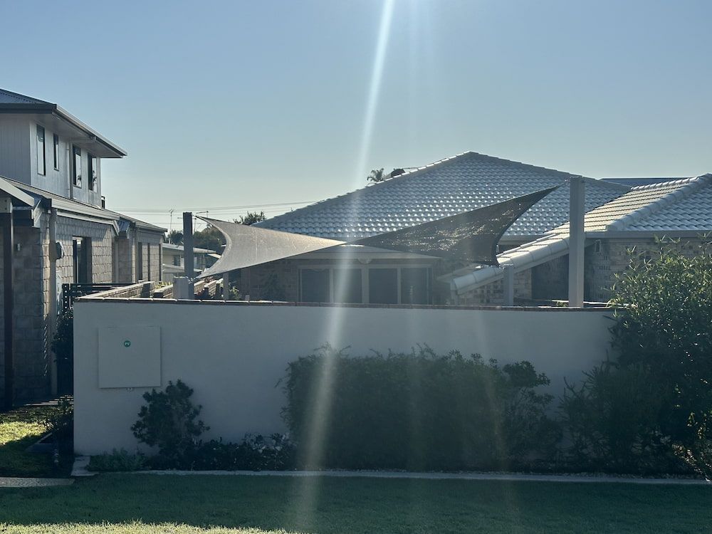 A House With A Large Umbrella In Front Of It — SPF Shades and Sails in Ballina, NSW