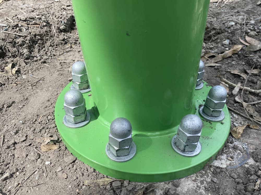 A Green Pole With Nuts And Bolts On It Is Sitting In The Dirt — SPF Shades and Sails in Tweed Heads West, NSW