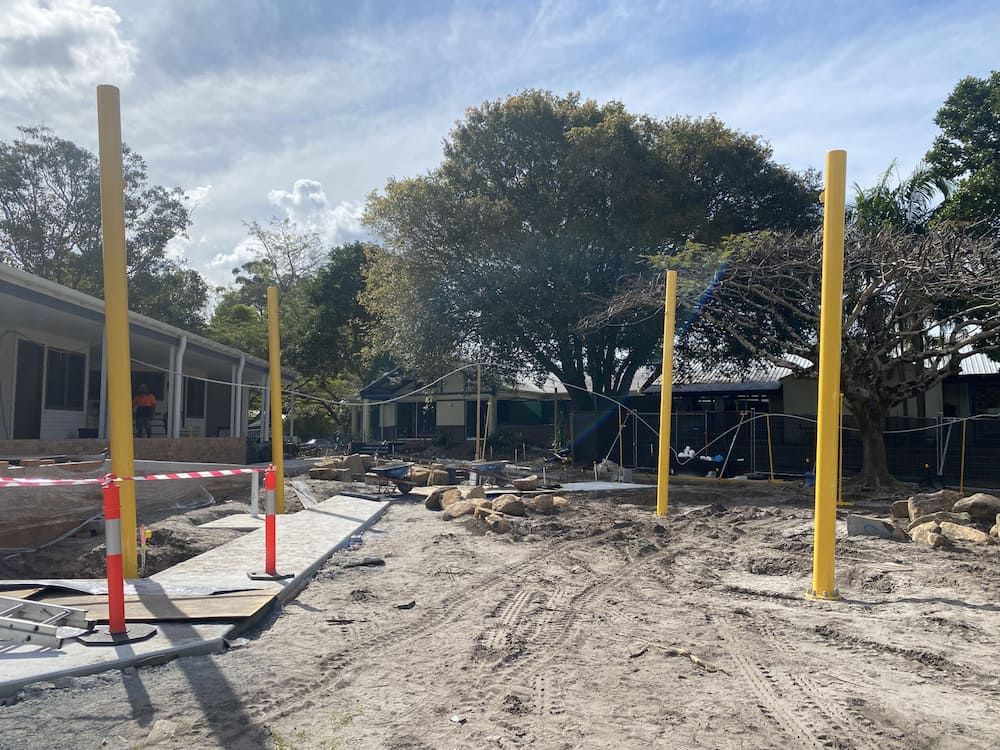 A Construction Site With A Lot Of Yellow Poles In The Dirt — SPF Shades and Sails in Tweed Heads West, NSW