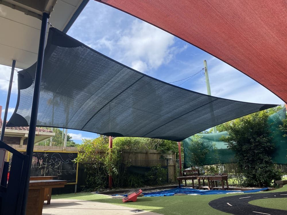 A Large Umbrella Is Covering A Pool In A Backyard — SPF Shades and Sails in Tweed Heads, NSW