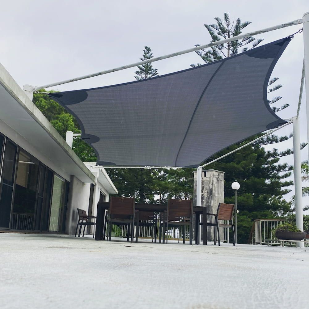 A Patio With A Table And Chairs Under An Umbrella — SPF Shades and Sails in Murwillumbah, NSW