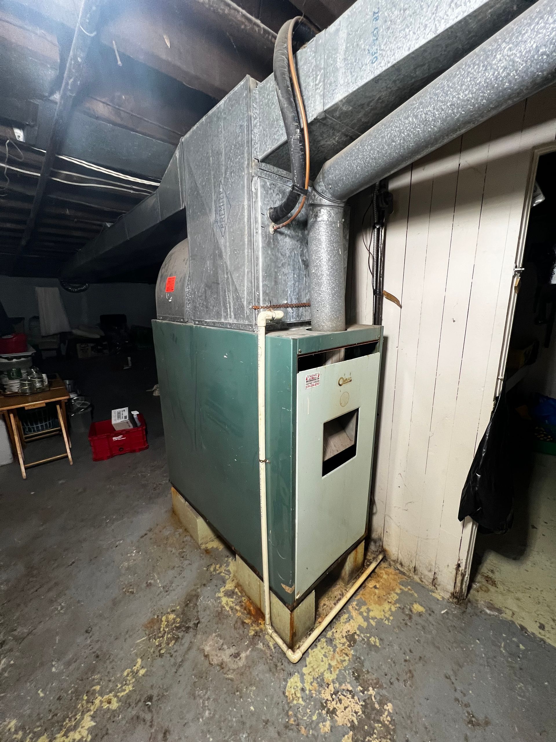 A green and white heater is sitting in a dark room.