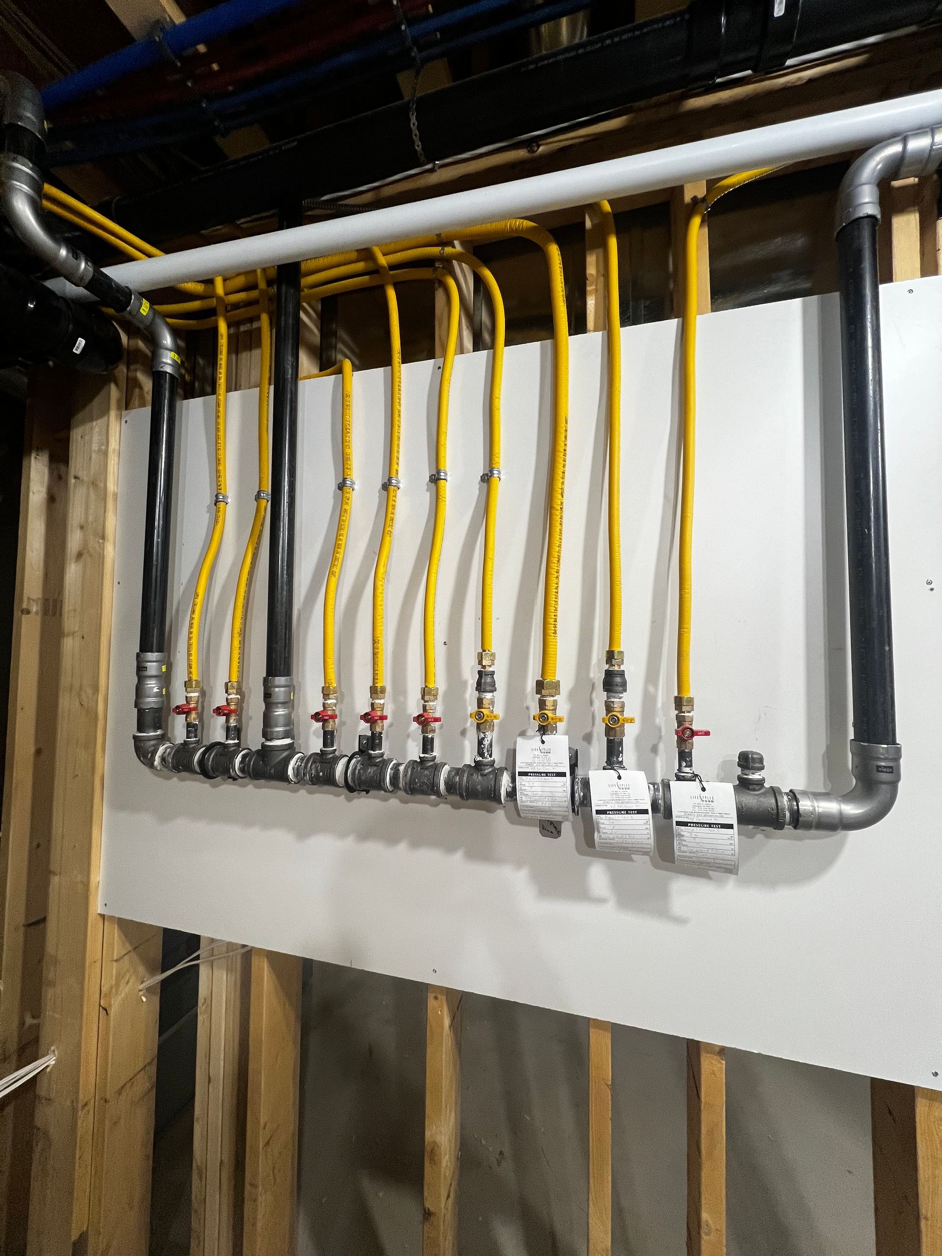 A bunch of pipes are hanging on a wall in a room.