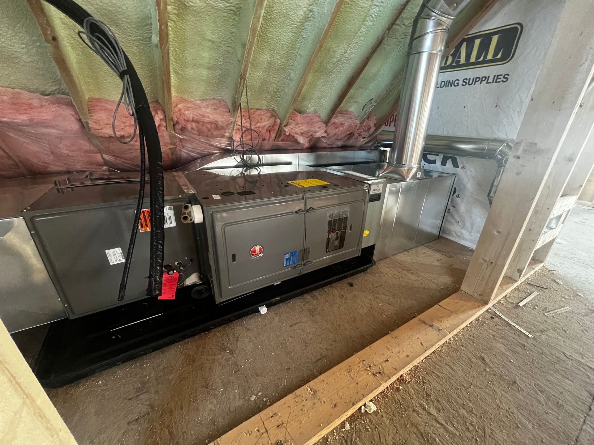 An air conditioner is sitting in the attic of a house.