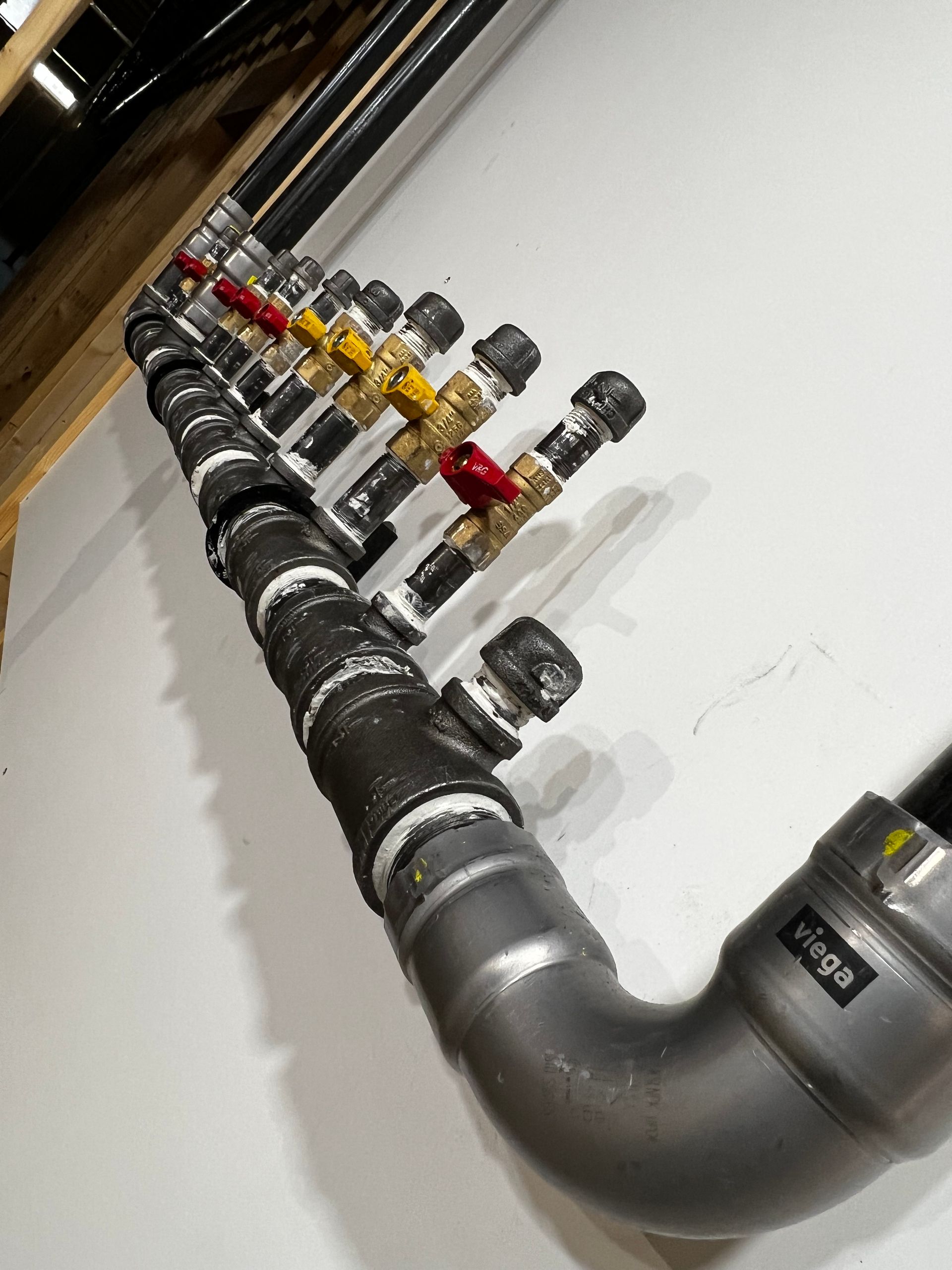 A row of pipes with valves on them and one of them has a label that says ' a ' on it