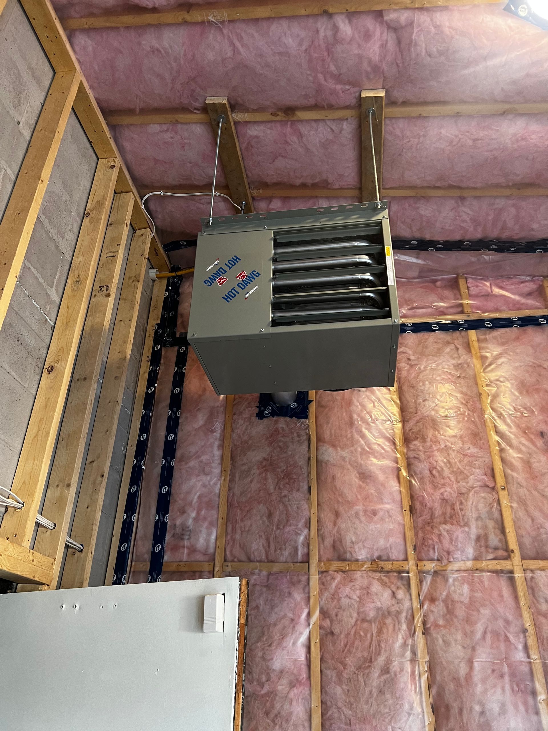 A heater is hanging from the ceiling of a building.