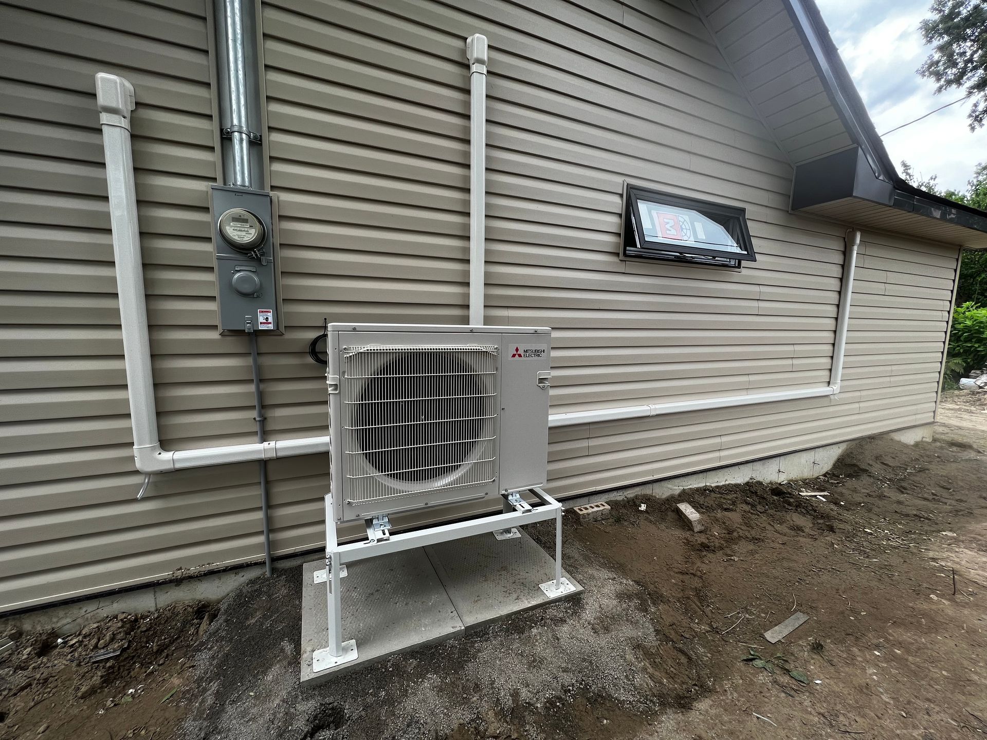A large air conditioner is installed on the side of a house.