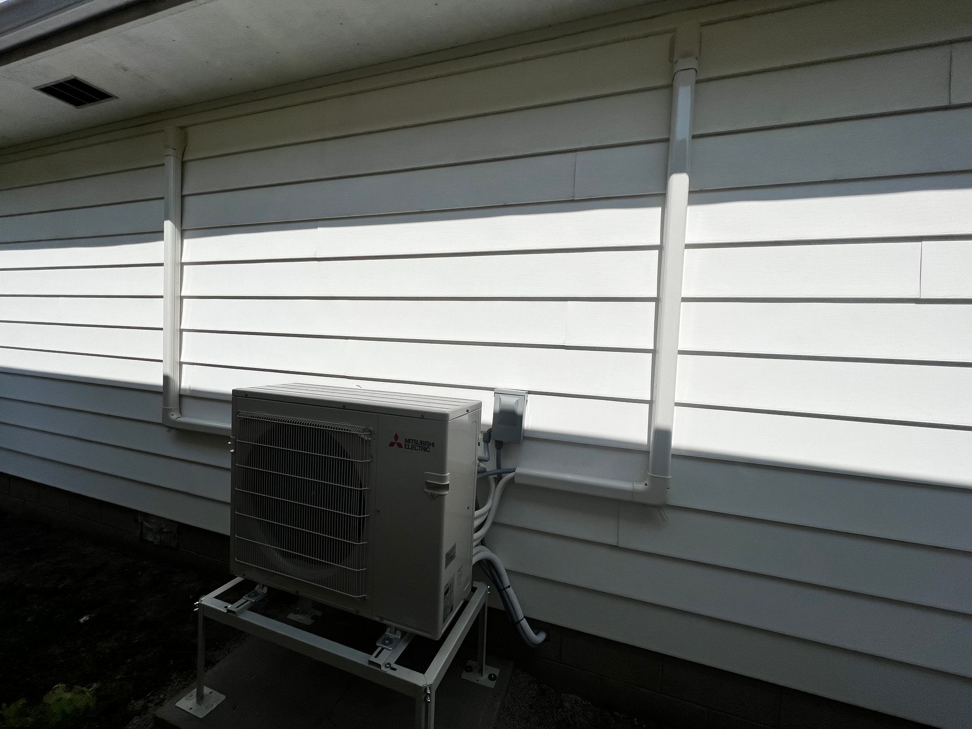 A white house with a large air conditioner on the side of it.
