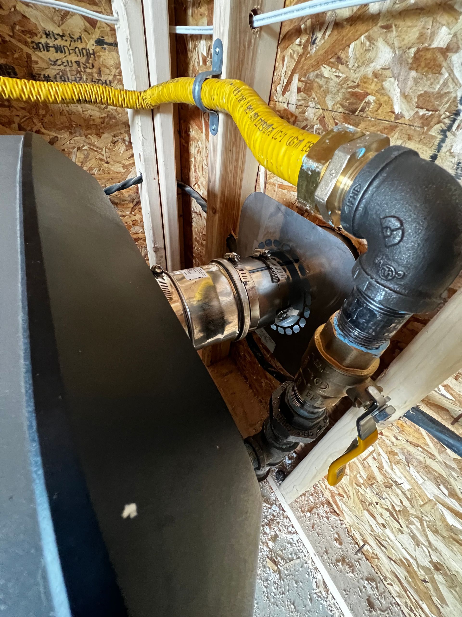 A close up of a pipe with a yellow hose attached to it.