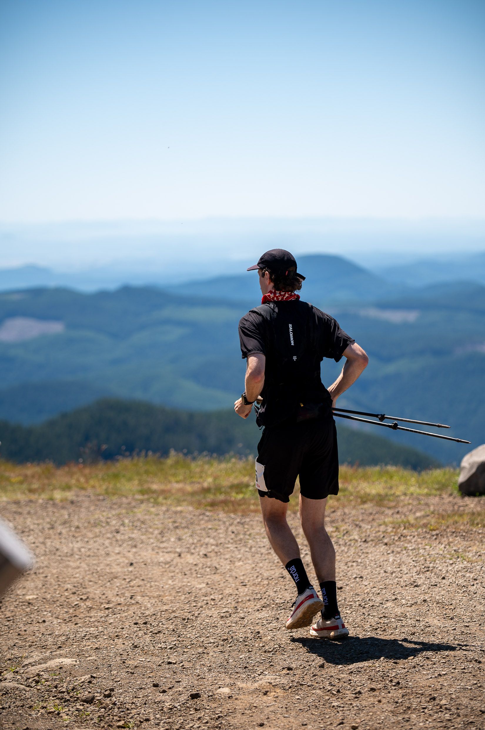 A man is running on a trail in the mountains.