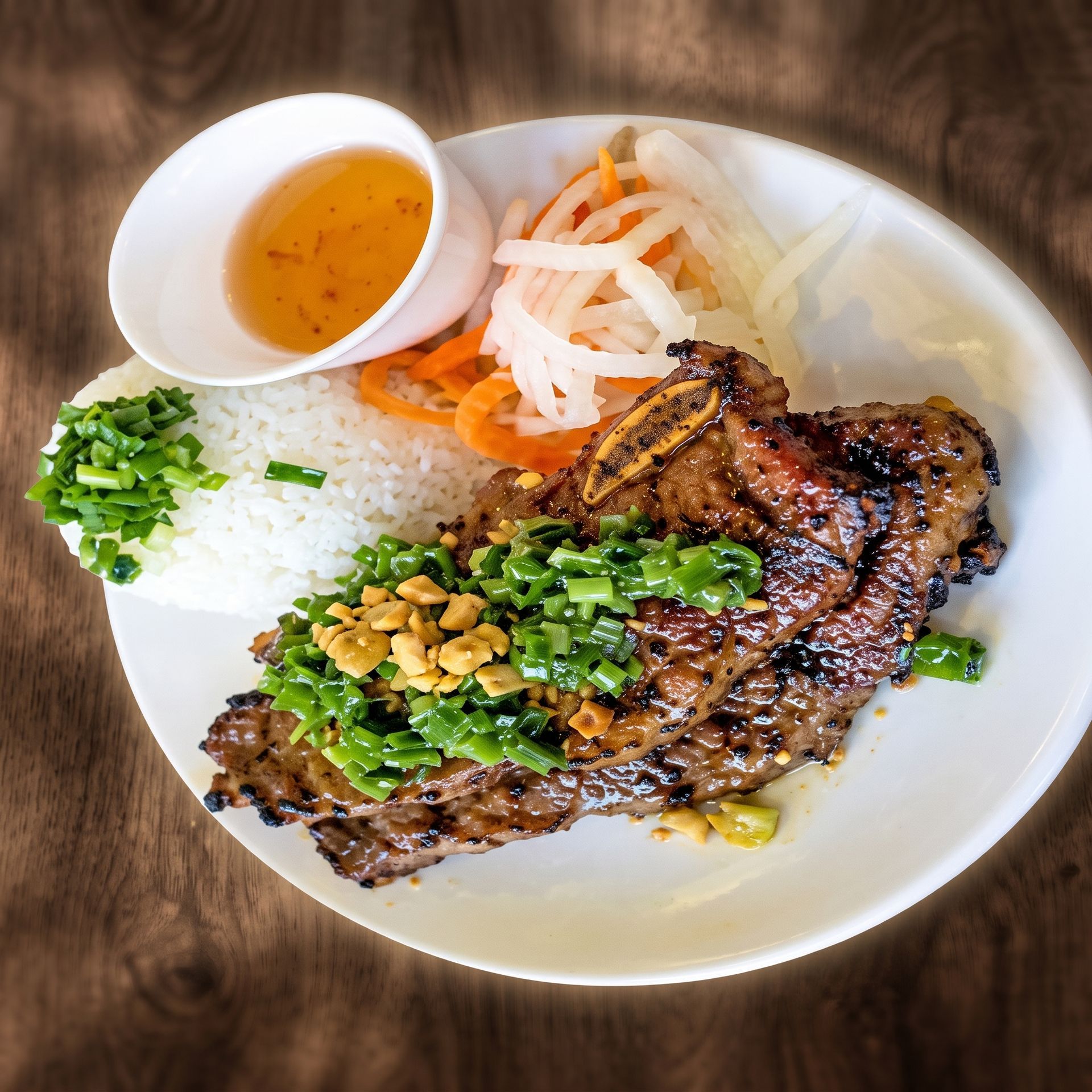 Grilled steak with rice, pickled vegetables, and dipping sauce on a white plate