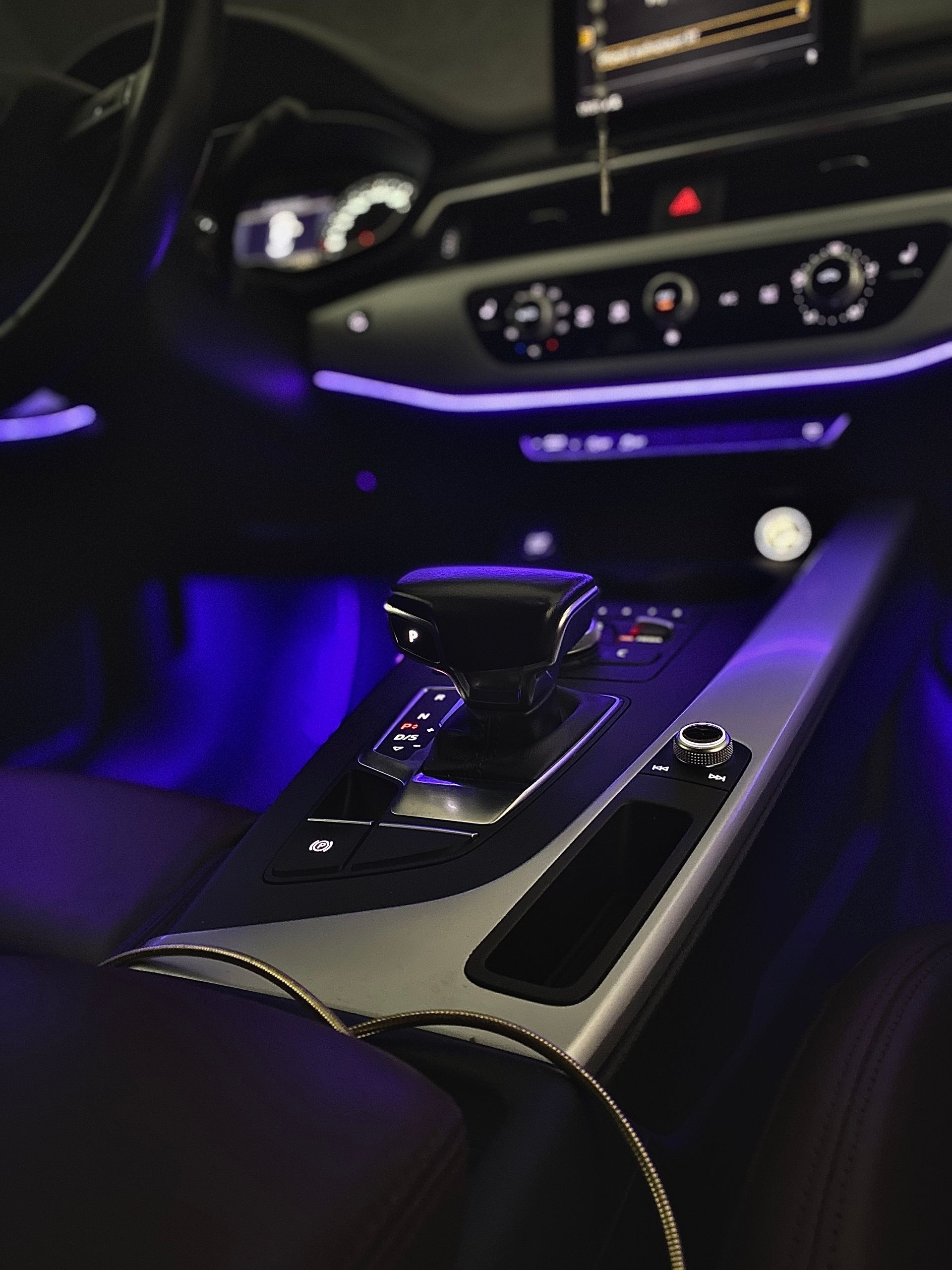 Purple-lit car interior with a glossy center console and gear selector