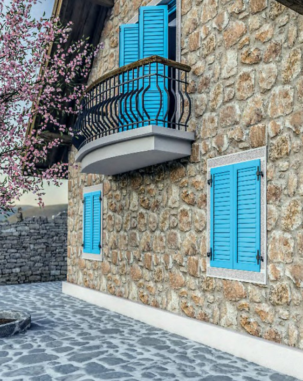 Edificio in pietra con persiane blu e balcone, accanto a un albero in fiore e pavimentazione in pietra.
