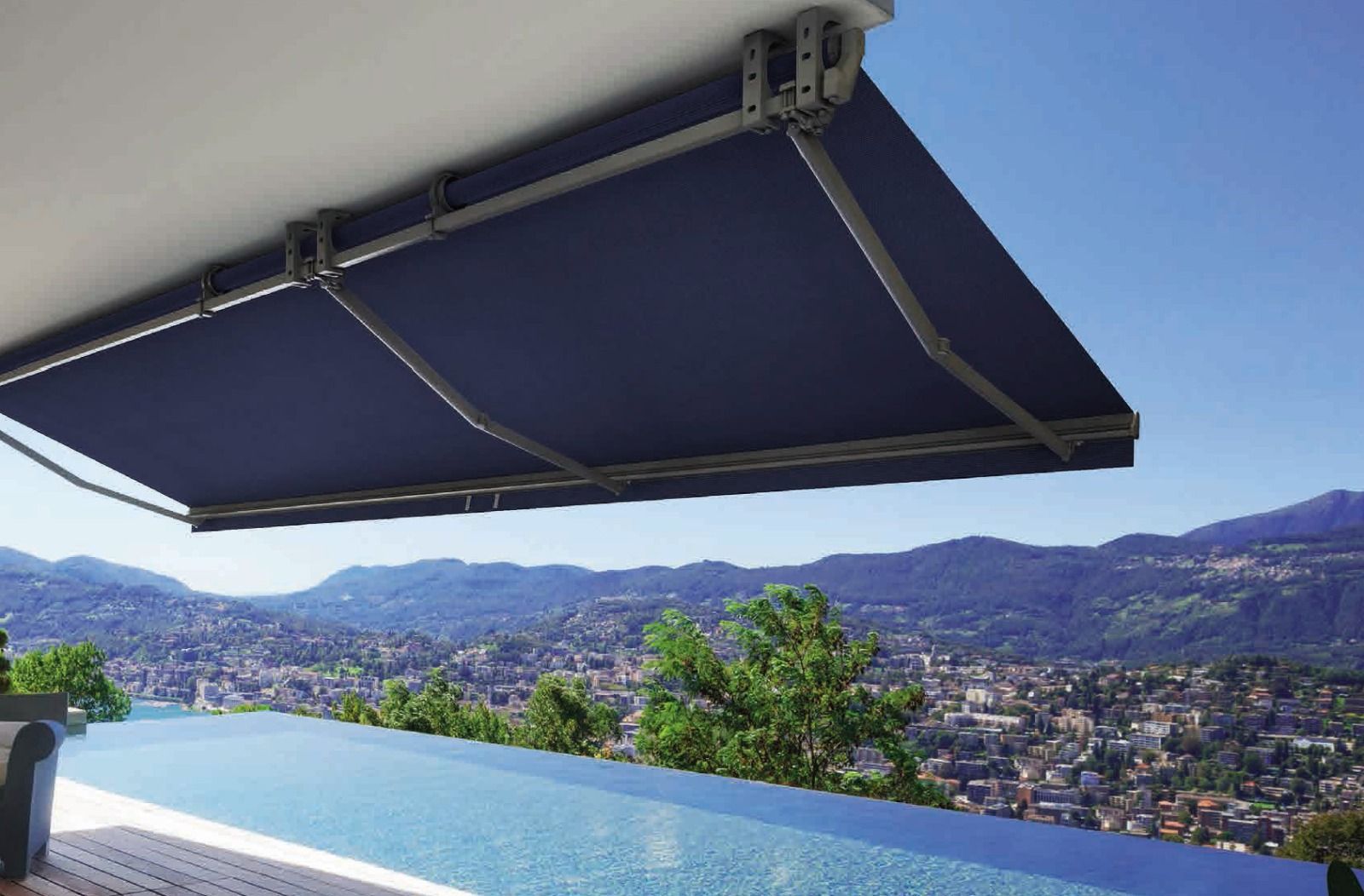 Tenda da sole retrattile blu sopra una piscina con vista sulle montagne e sulla città.