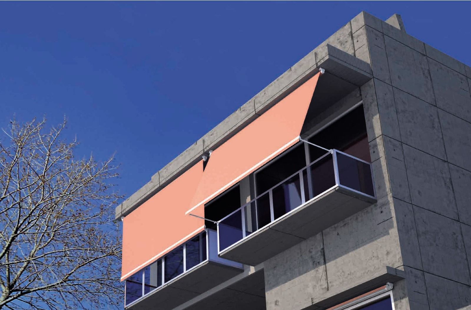 Esterno dell'edificio con una tenda da sole arancione retrattile sopra un balcone; cielo azzurro brillante.