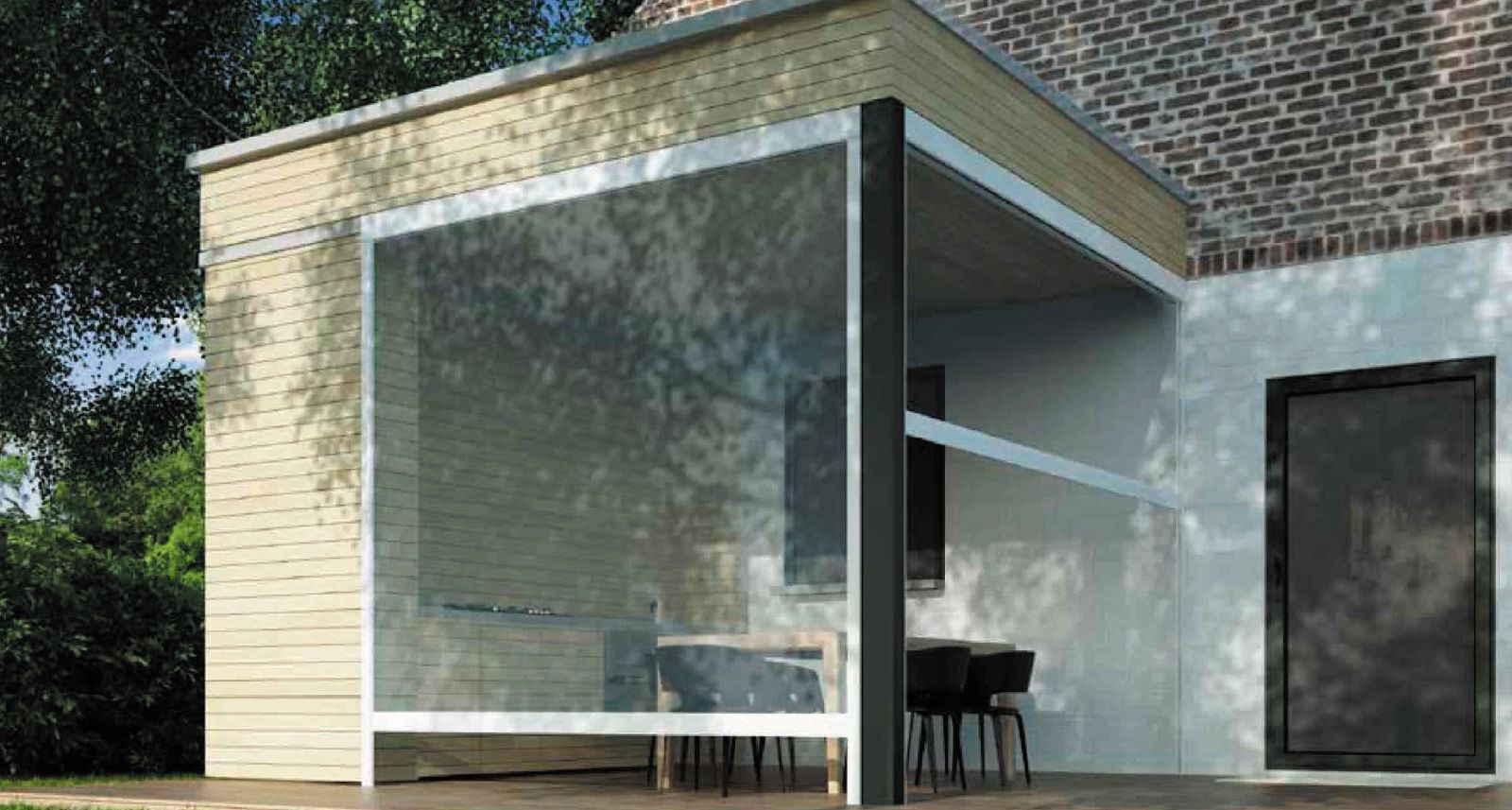 Patio esterno coperto con schermo retrattile, tavolo e sedie. Edificio beige e muro di mattoni sullo sfondo.