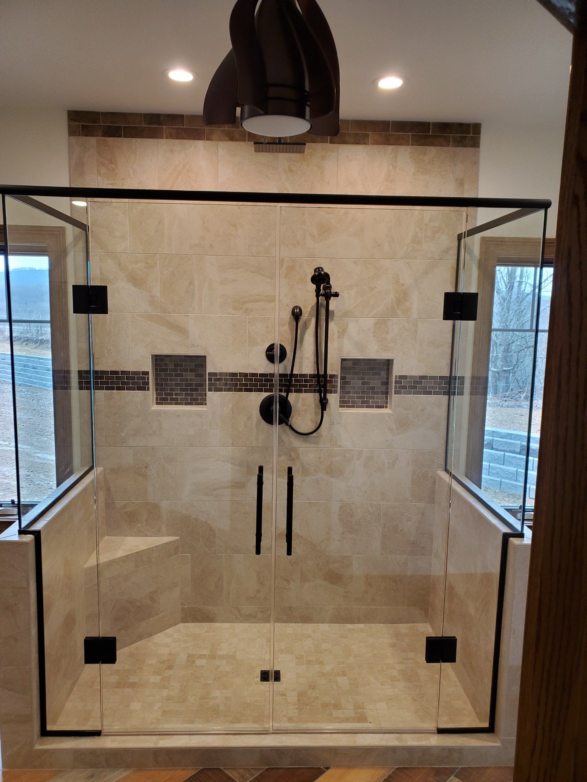 A bathroom with a walk in shower with a glass door