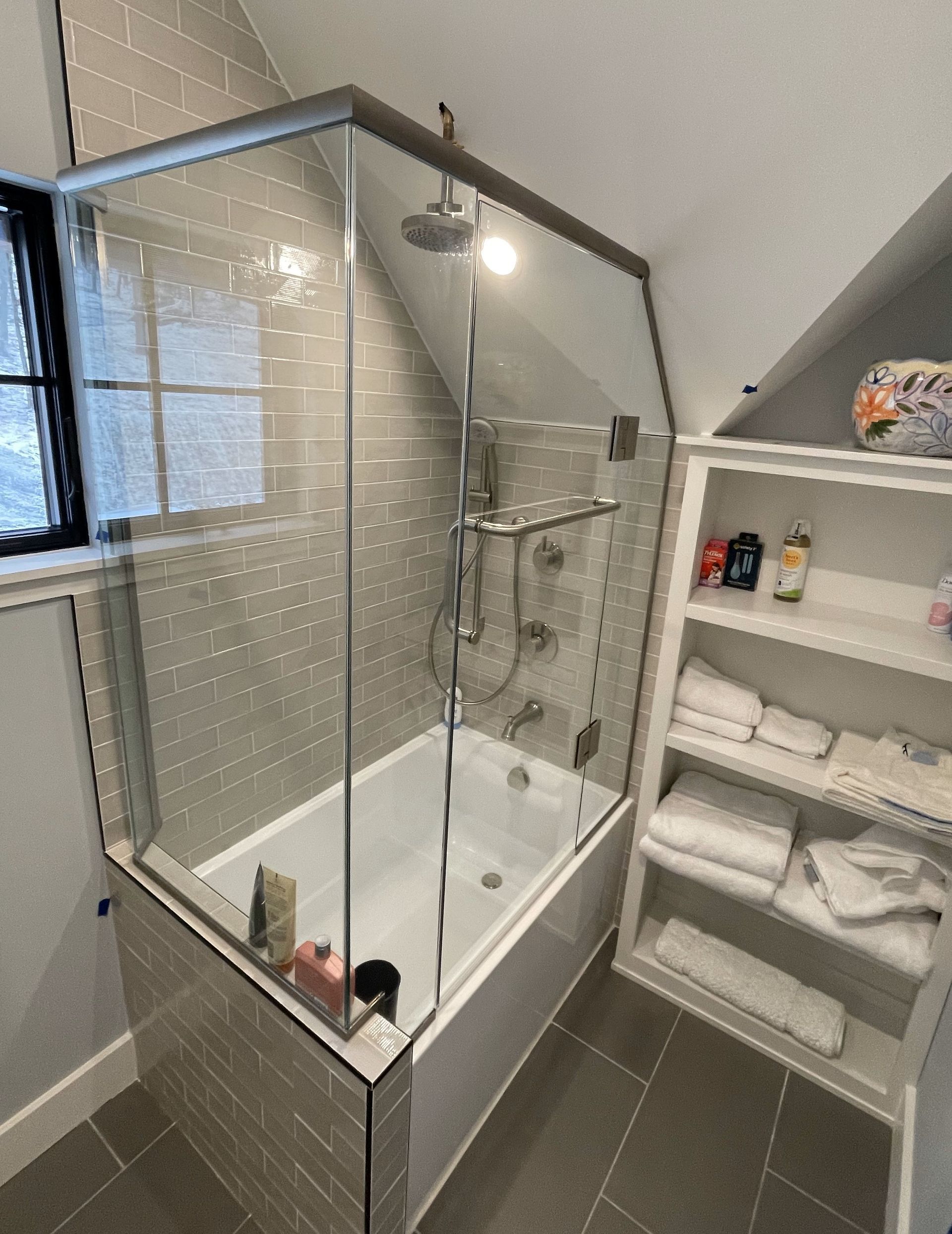A bathroom with a bathtub and a shower with a glass door.