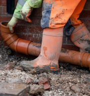 sewer line repair going in through man hole in street.