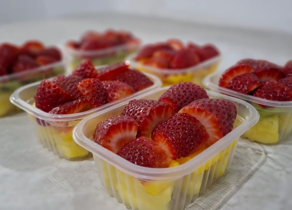 Recipientes con fresas sobre rodajas de piña.