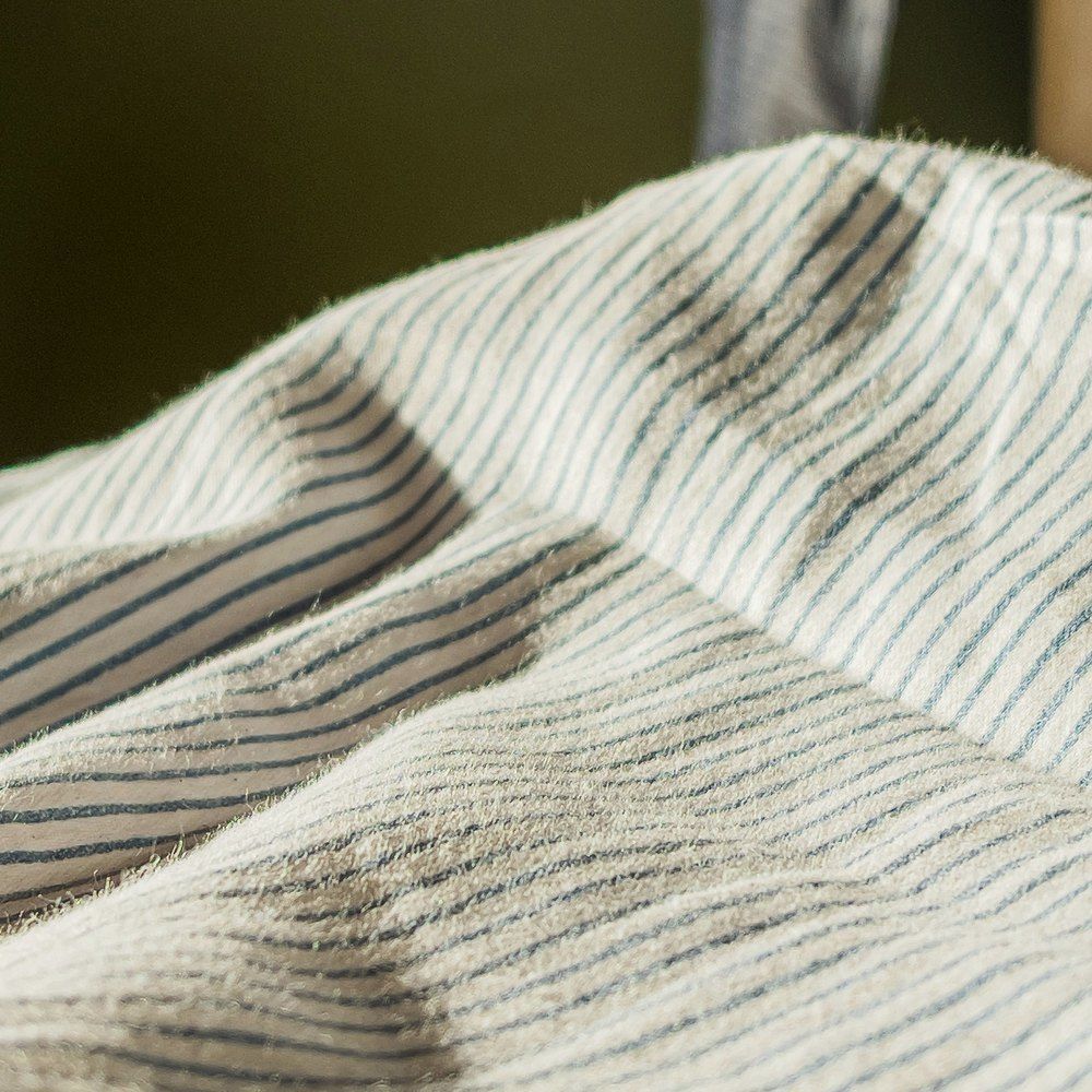 A forearm with a small IV line secured under clear dressing, resting on a chair arm.