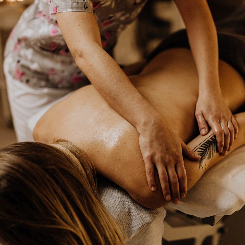 A clinician reviewing a patient's surgical discharge paperwork before a recovery massage appointment begins.