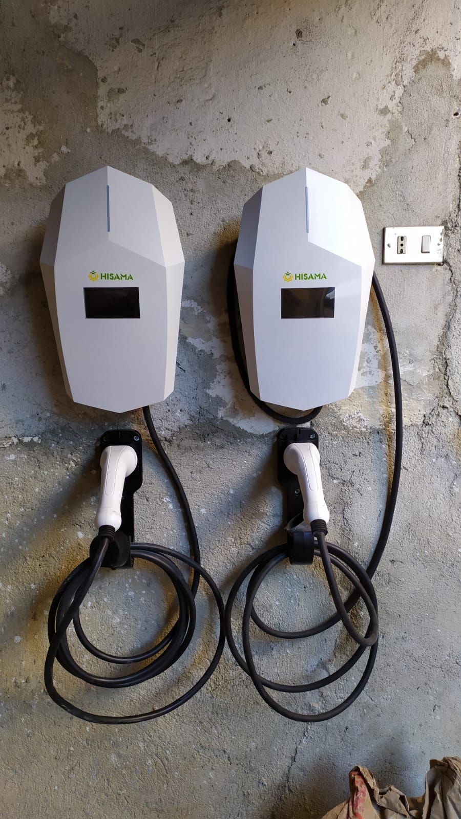 Due stazioni di ricarica per auto elettriche sono appese a una parete.