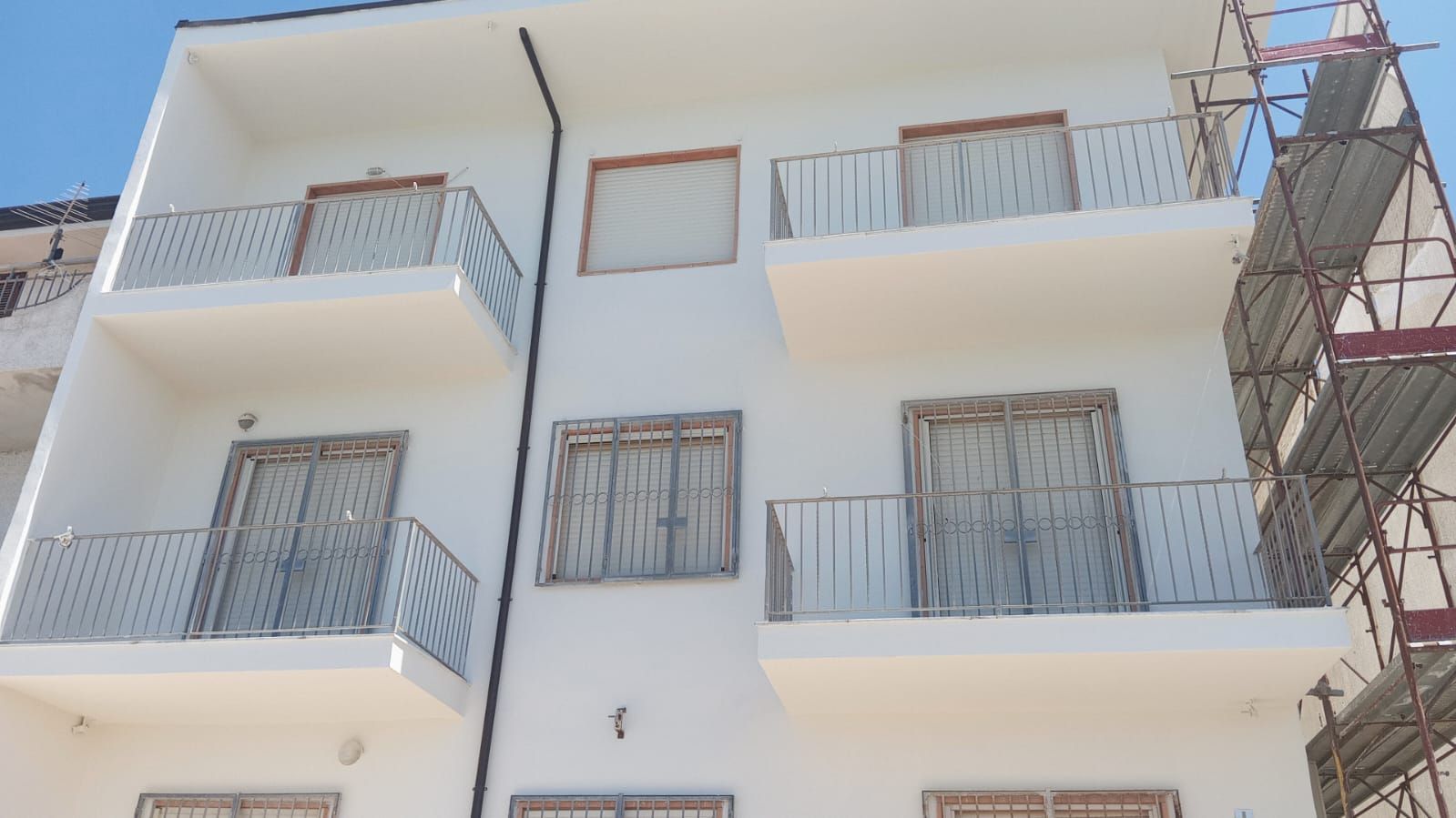 Un edificio bianco con balconi e impalcature attorno