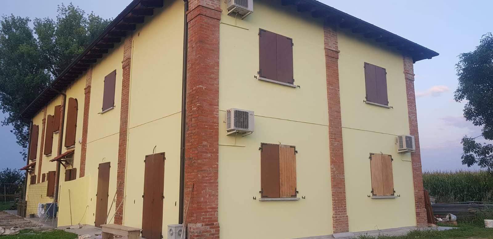 Un grande edificio giallo con un camino sul lato