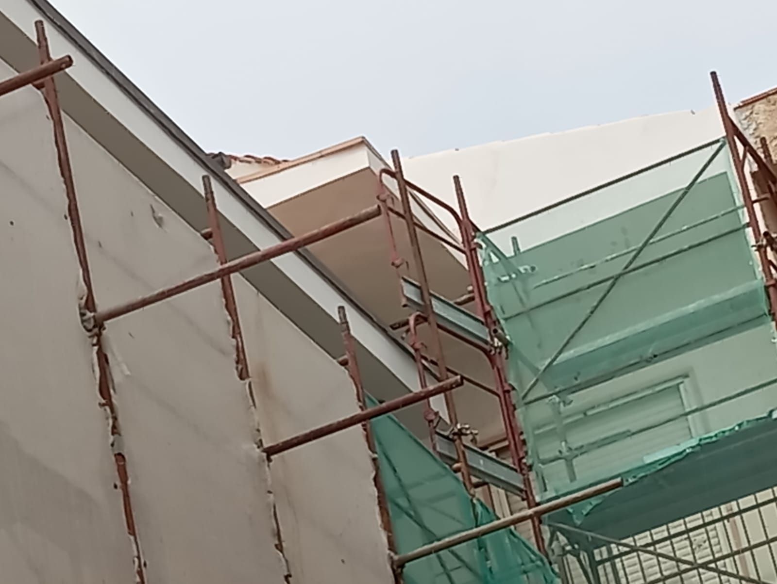 Un edificio in costruzione con impalcature sul lato