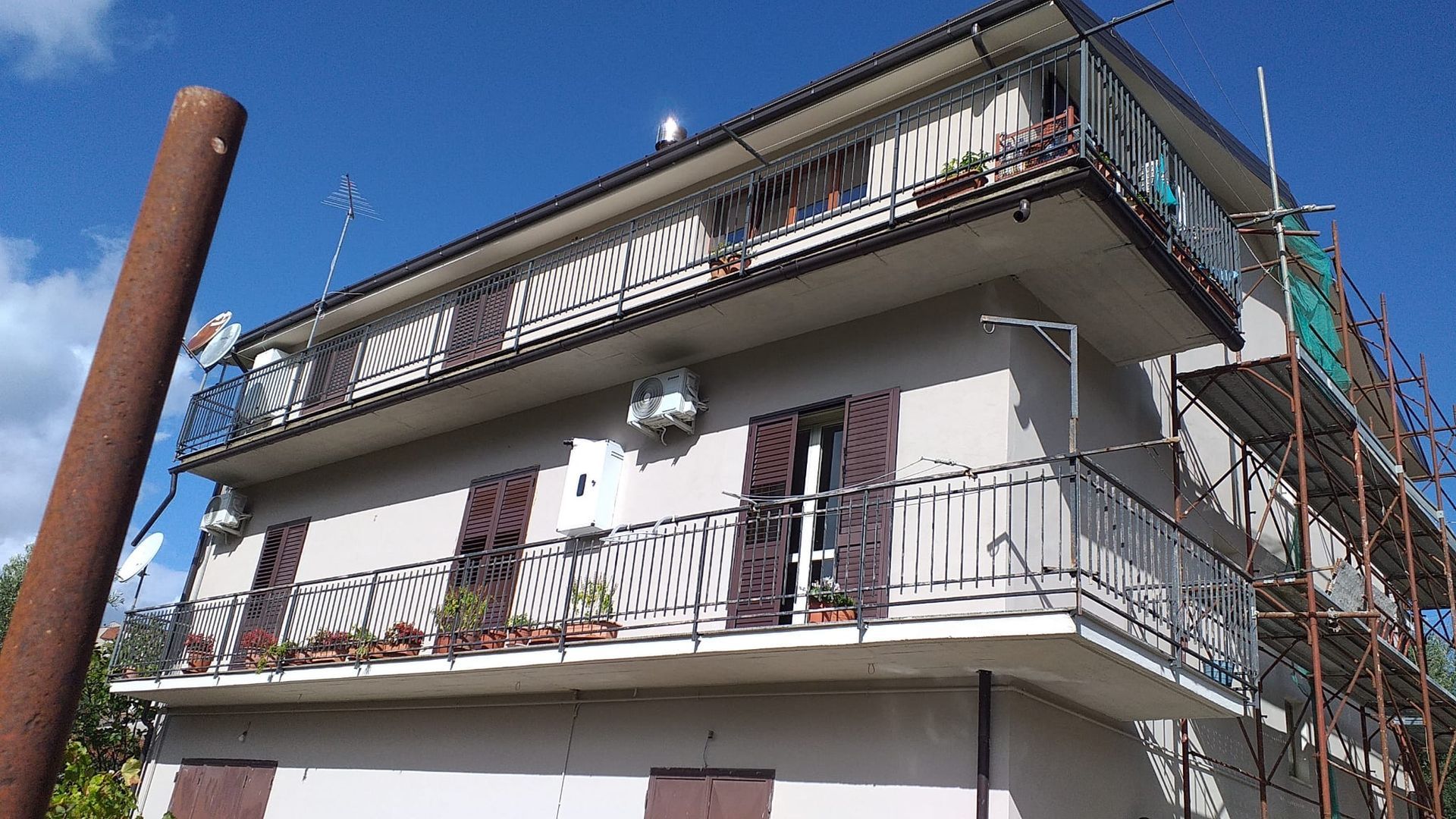 Una grande casa con un balcone e impalcature intorno