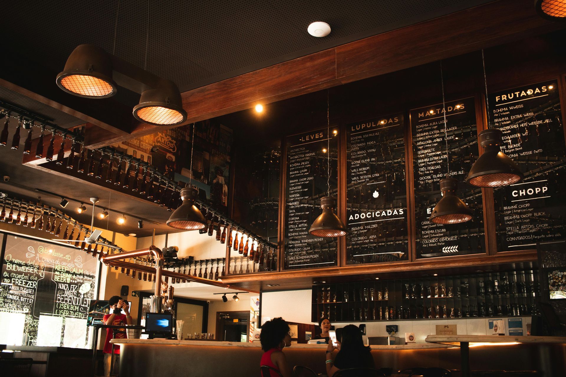 A restaurant with people sitting at tables and a bar