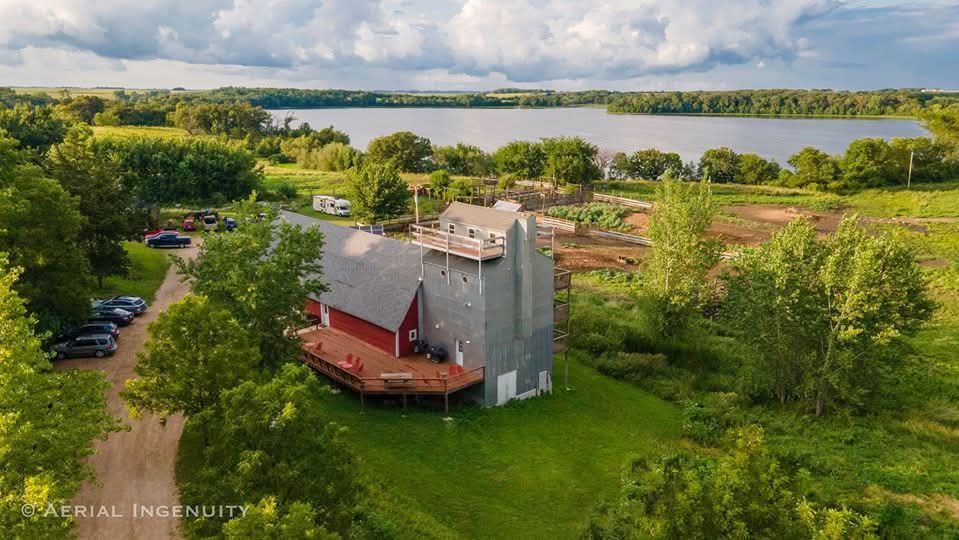 A large brown barn is sitting in the middle of a field.